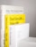 Several books are stacked vertically with their spines facing outward. The titles are visible, including 'Design, When Everybody Designs,' 'Don't Get a Job... Make a Job,' and 'Ex-formation.' The books have a clean and minimalist aesthetic, with prominent use of white and yellow colors.