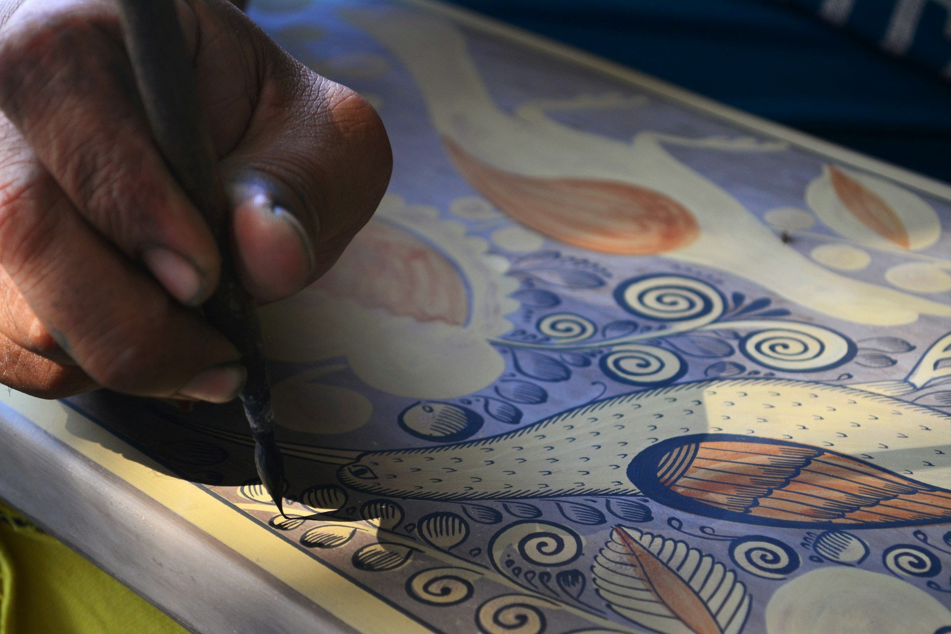 Close-up of hands crafting a traditional art piece, showcasing intricate patterns and textures inspired by family heritage.