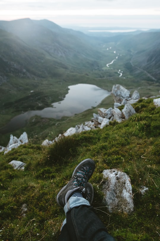 person laying on green grass field in Glyder Fawr United Kingdom