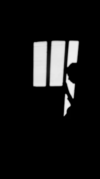 Monochrome still from a short film showing a silhouette against a bright window.