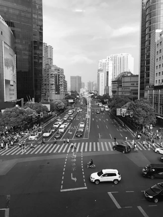 A dynamic black and white shot of city streets bustling with life and movement.