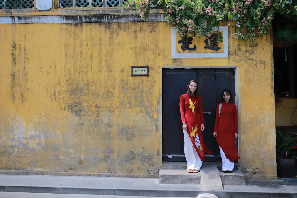 two woman standing in front of black gate