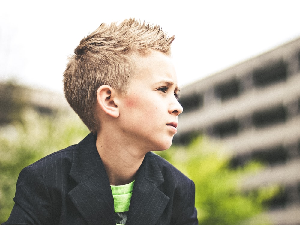 selective focus photography boy looking at his left during day