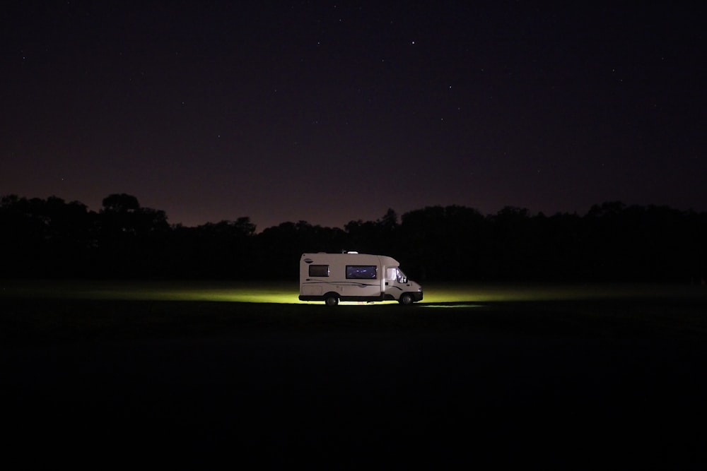 RV blanco en la carretera durante la noche