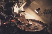 person pouring coffee beans on a machine