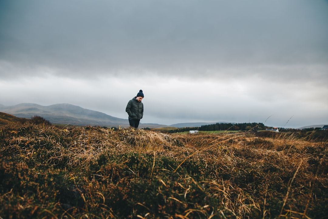 man walking on grass field