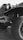 A close-up view of the front part of an old, rugged truck with large, off-road tires. The image features the truck's headlight, grille, and part of the chassis. The tire tread is prominently visible, emphasizing its heavy-duty nature.