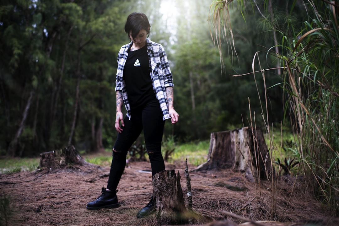 woman standing looking into log,