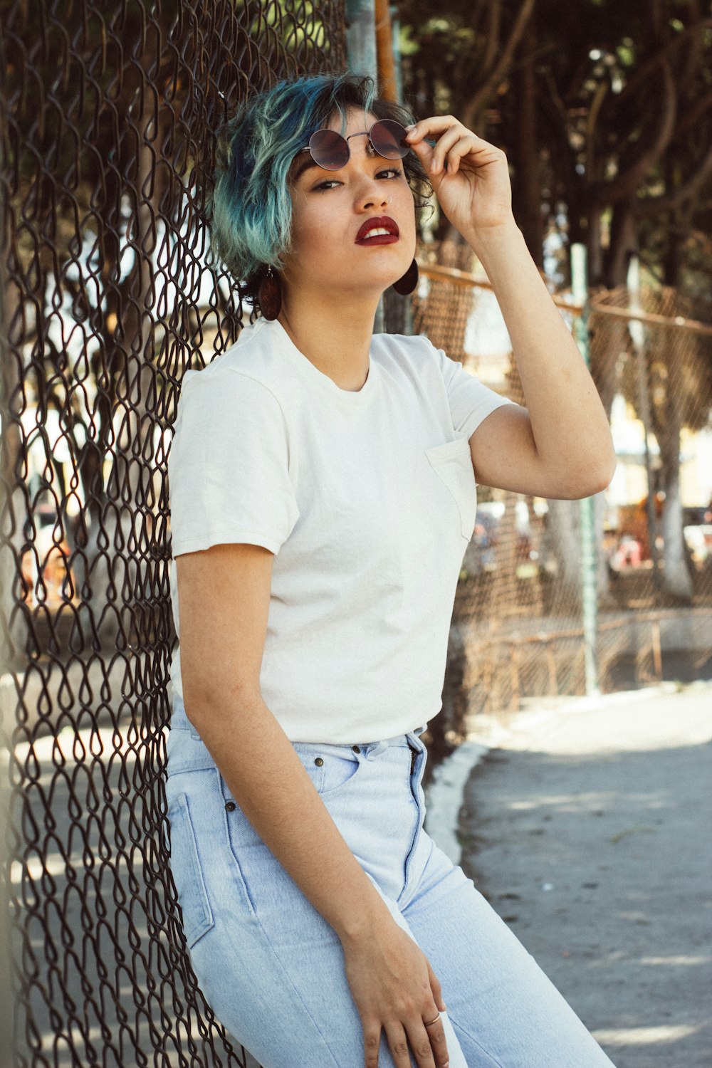 woman holding black framed hippie sunglasses