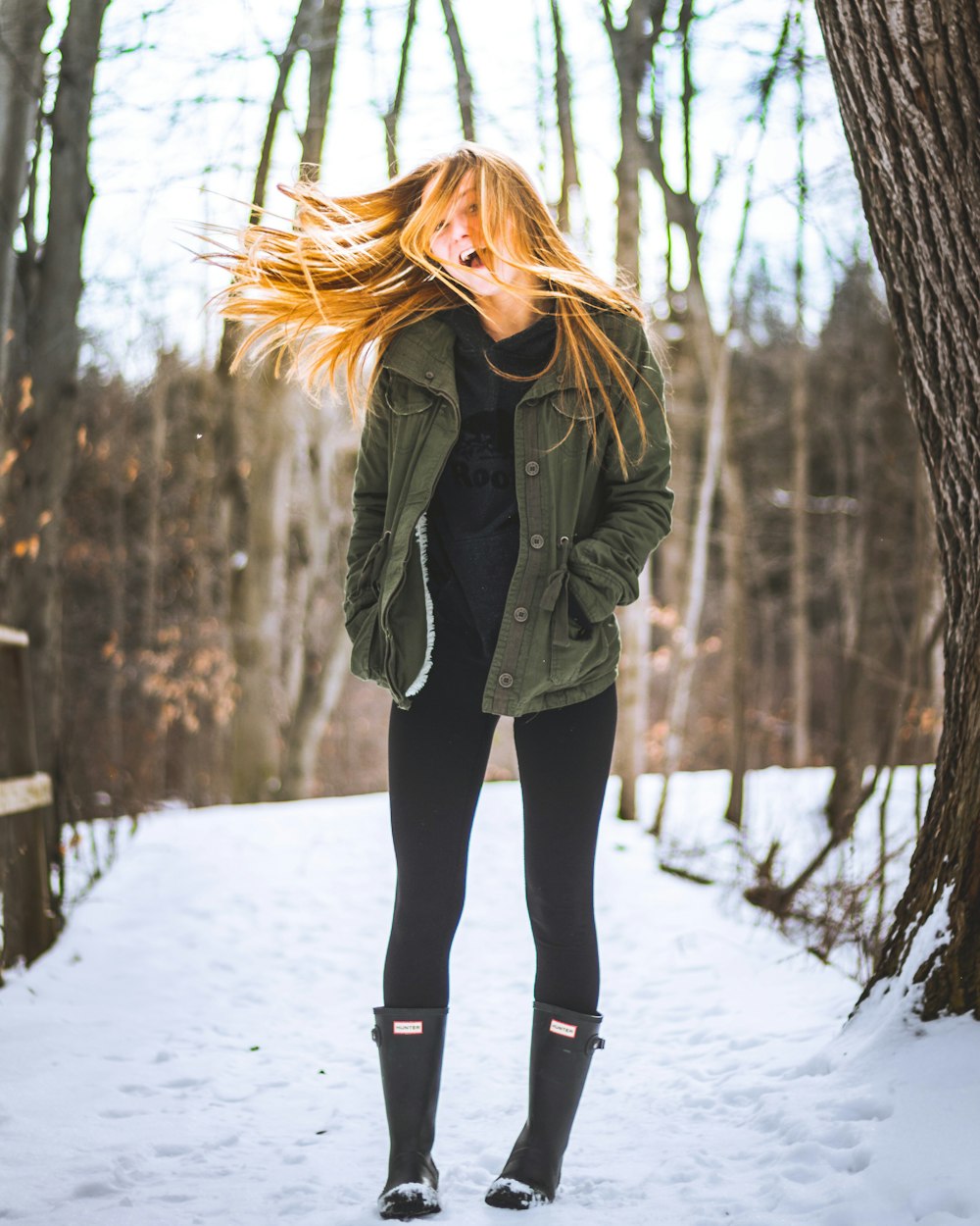 woman standing between tree leafless trees