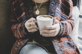 person holding white ceramic cup