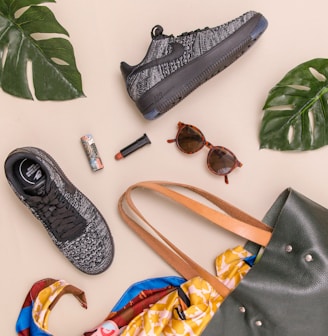 photo of bag, sneakers, and sunglasses on beige surface