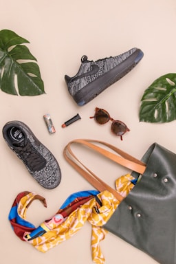 photo of bag, sneakers, and sunglasses on beige surface