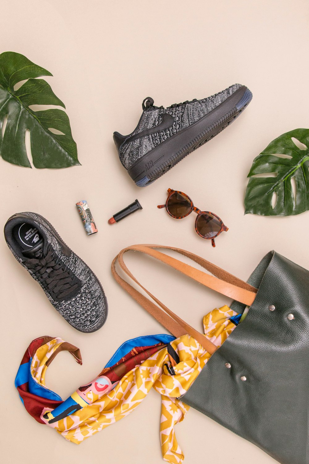 photo of bag, sneakers, and sunglasses on beige surface