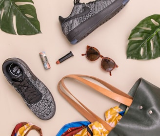 photo of bag, sneakers, and sunglasses on beige surface