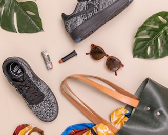 photo of bag, sneakers, and sunglasses on beige surface