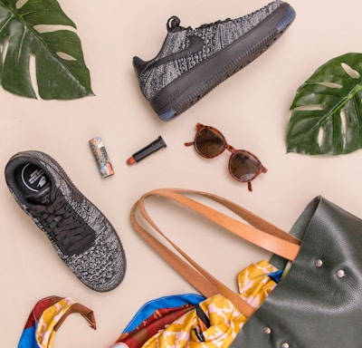 photo of bag, sneakers, and sunglasses on beige surface
