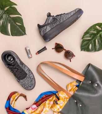 photo of bag, sneakers, and sunglasses on beige surface