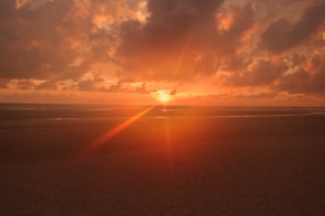 A vibrant sunset over a serene beach setting.