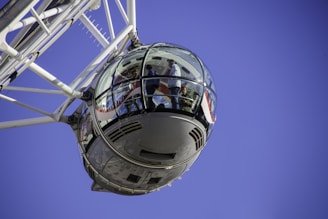 people inside white ferris wheel pod