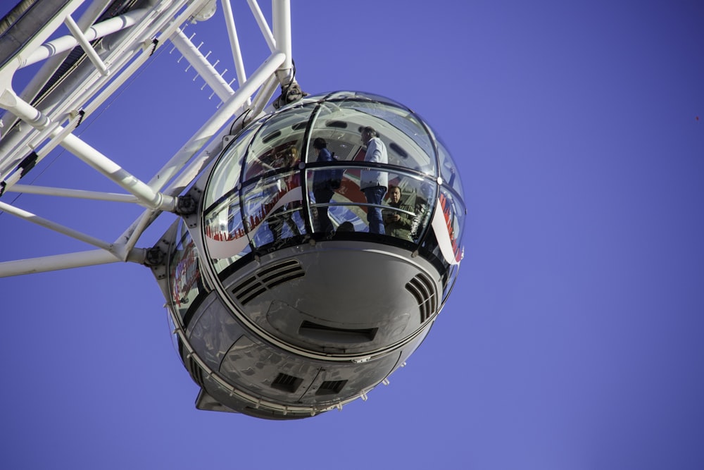 people inside white ferris wheel pod