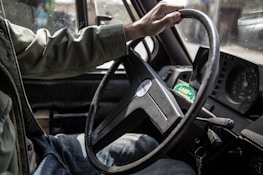 person holding black steering wheel