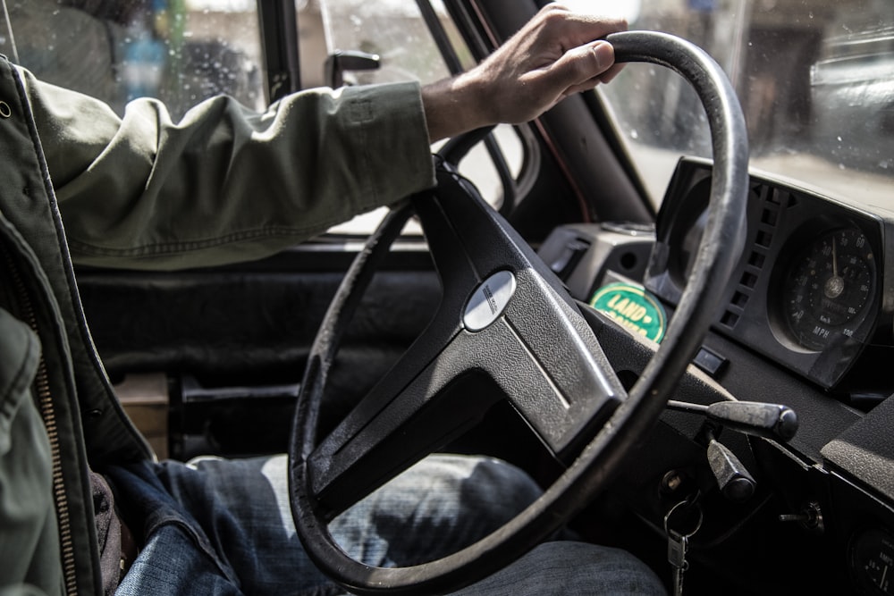 person holding black steering wheel