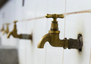 Close-up of a professional engineer installing a precision water-saving device in a modern hotel bathroom.
