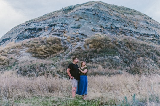 man and woman standing near mountain in Drumheller Canada
