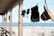 A stylish beach cover-up hanging on a wooden fence with the ocean in the background.