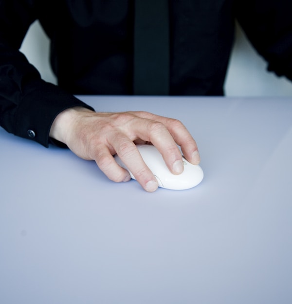 person holding white cordless computer mouse