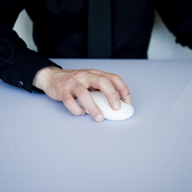 person holding white cordless computer mouse