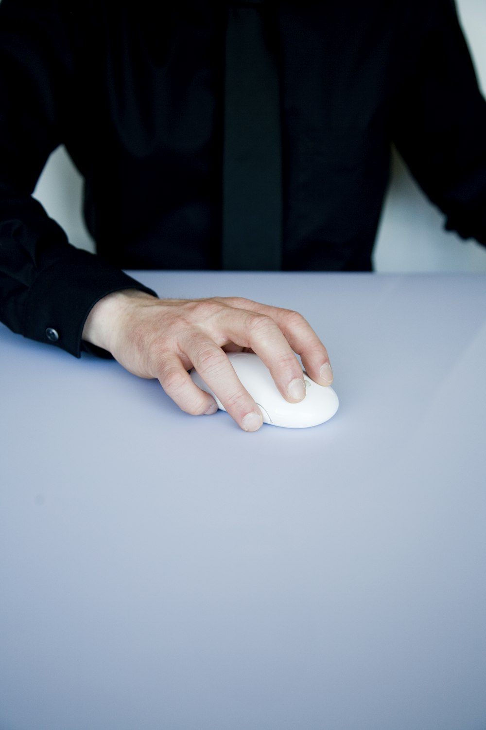pessoa segurando mouse de computador branco sem fio
