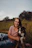 woman sitting beside a black and white dog