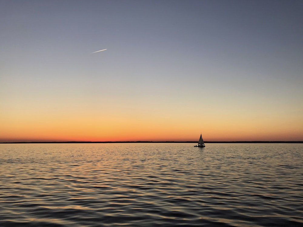 sail boat on calm body of water