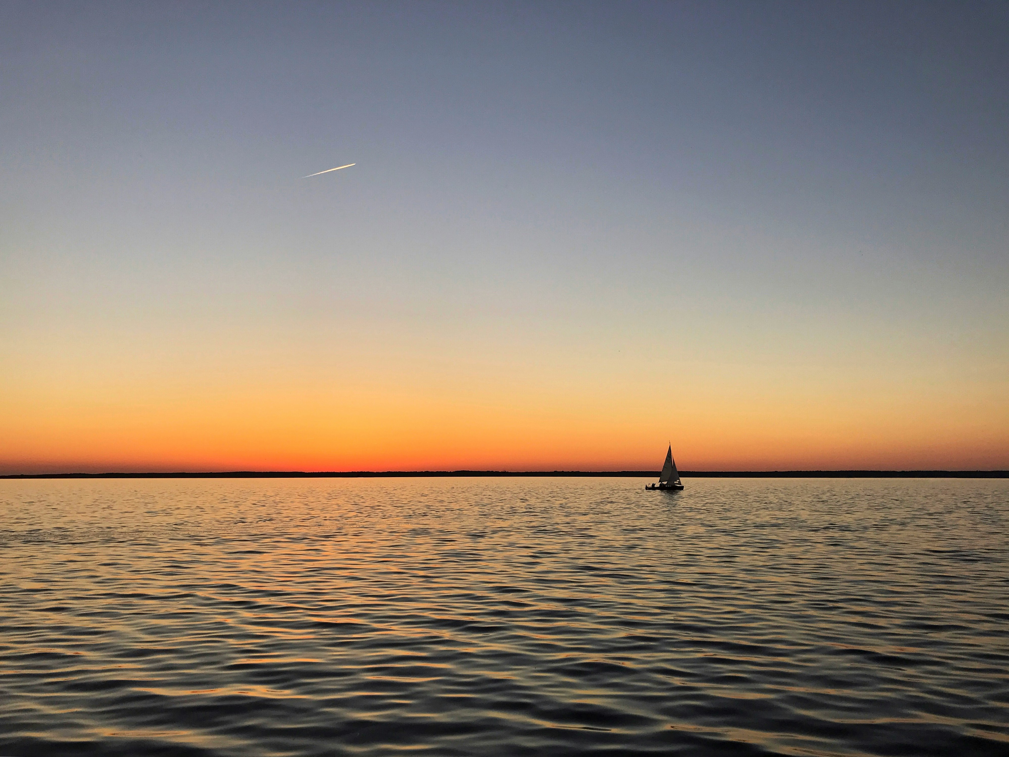 sail boat on calm body of water