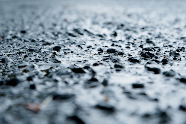 Close-up of freshly paved asphalt with a smooth, dark surface reflecting subtle golden light.