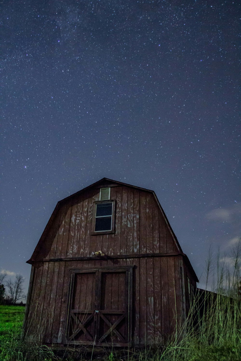 brown wooden barn under starry sky