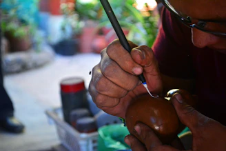 Close-up of Monique Brown carefully laser engraving a wooden coaster in her cozy Machakos studio.