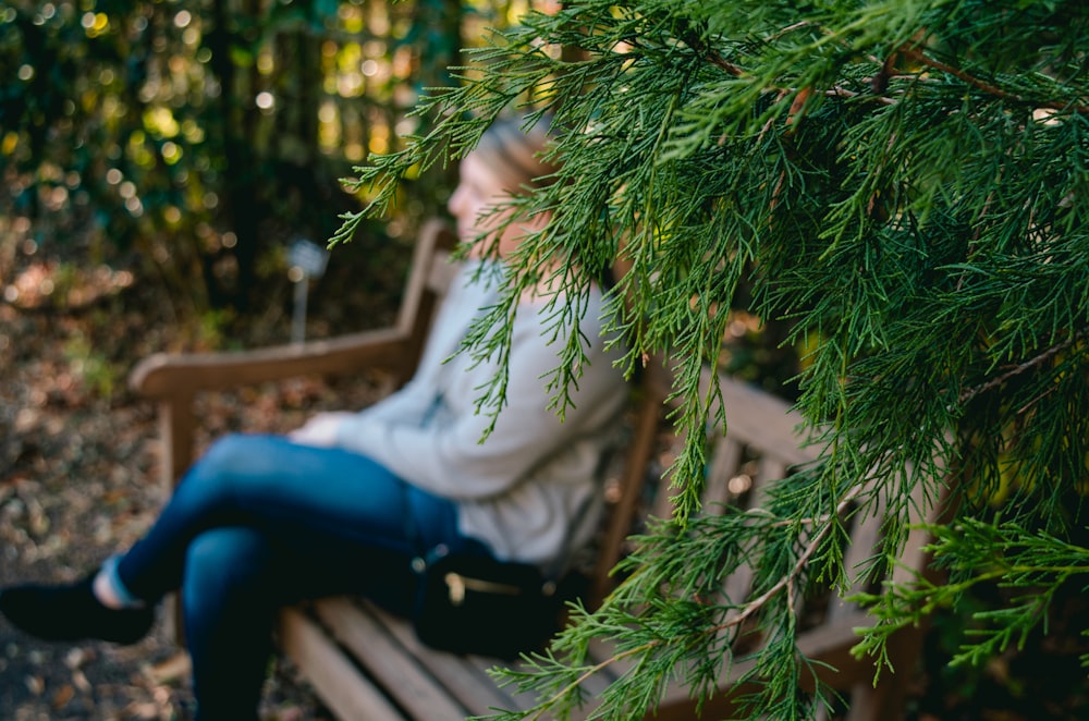 mulher sentada no banco de madeira marrom