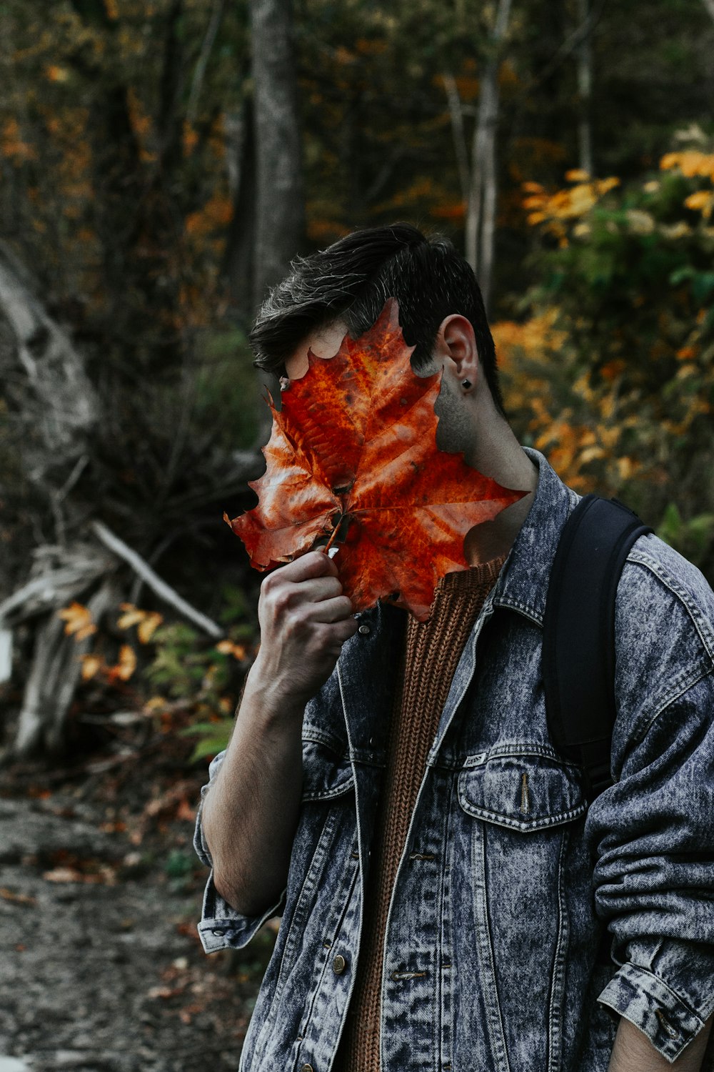 나뭇잎으로 얼굴을 덮는 남자