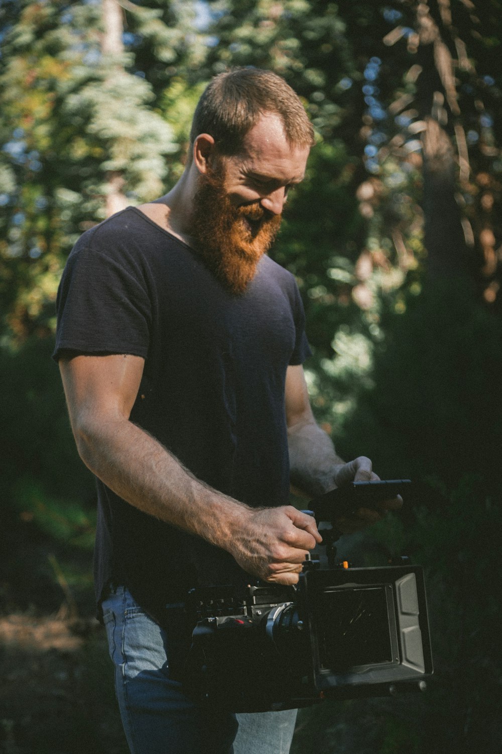 Homem segurando gravador de vídeo preto na floresta