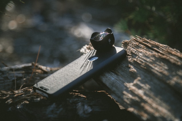 A close-up of a vibrant Color Case protecting a smartphone resting on a wooden table with sunlight streaming in.