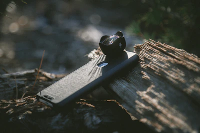 Close-up of a sleek Caseey phone case resting on a city bench, sunlight casting soft shadows.