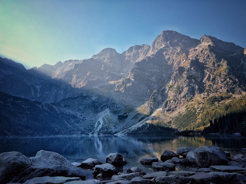 calm water front of mountain at daytime