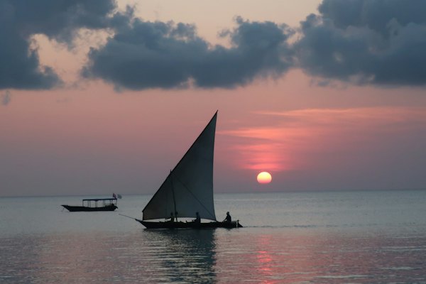 Photograph of sail boat on calm body of water during golden hour — Zanzibar, Tanzania