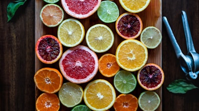 assorted sliced citrus fruits on brown wooden chopping board