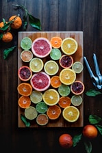 assorted sliced citrus fruits on brown wooden chopping board