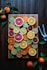assorted sliced citrus fruits on brown wooden chopping board