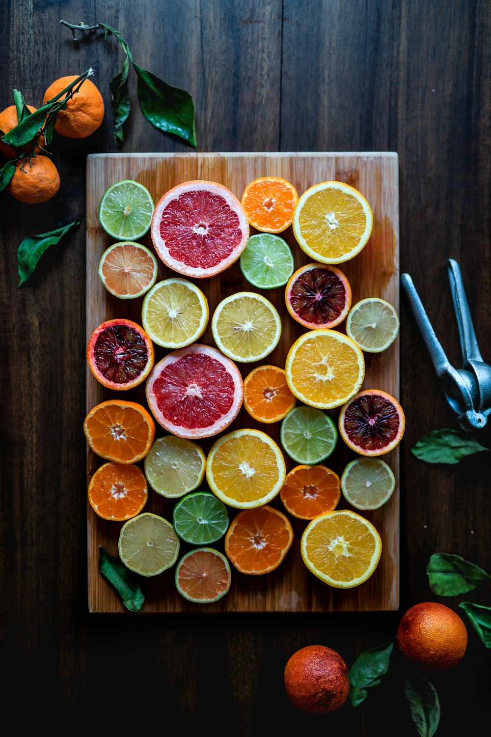 frutas cítricas fatiadas variadas em tábua de cortar madeira marrom